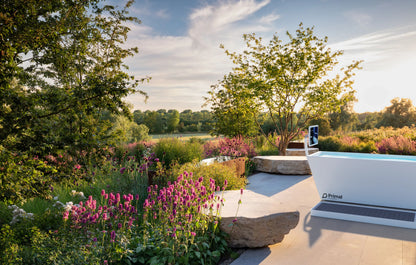 Blizzard cold plunge tub from Primal Plunges shown in a backyard overlooking a golf course with a touchscreen running PrimalOS