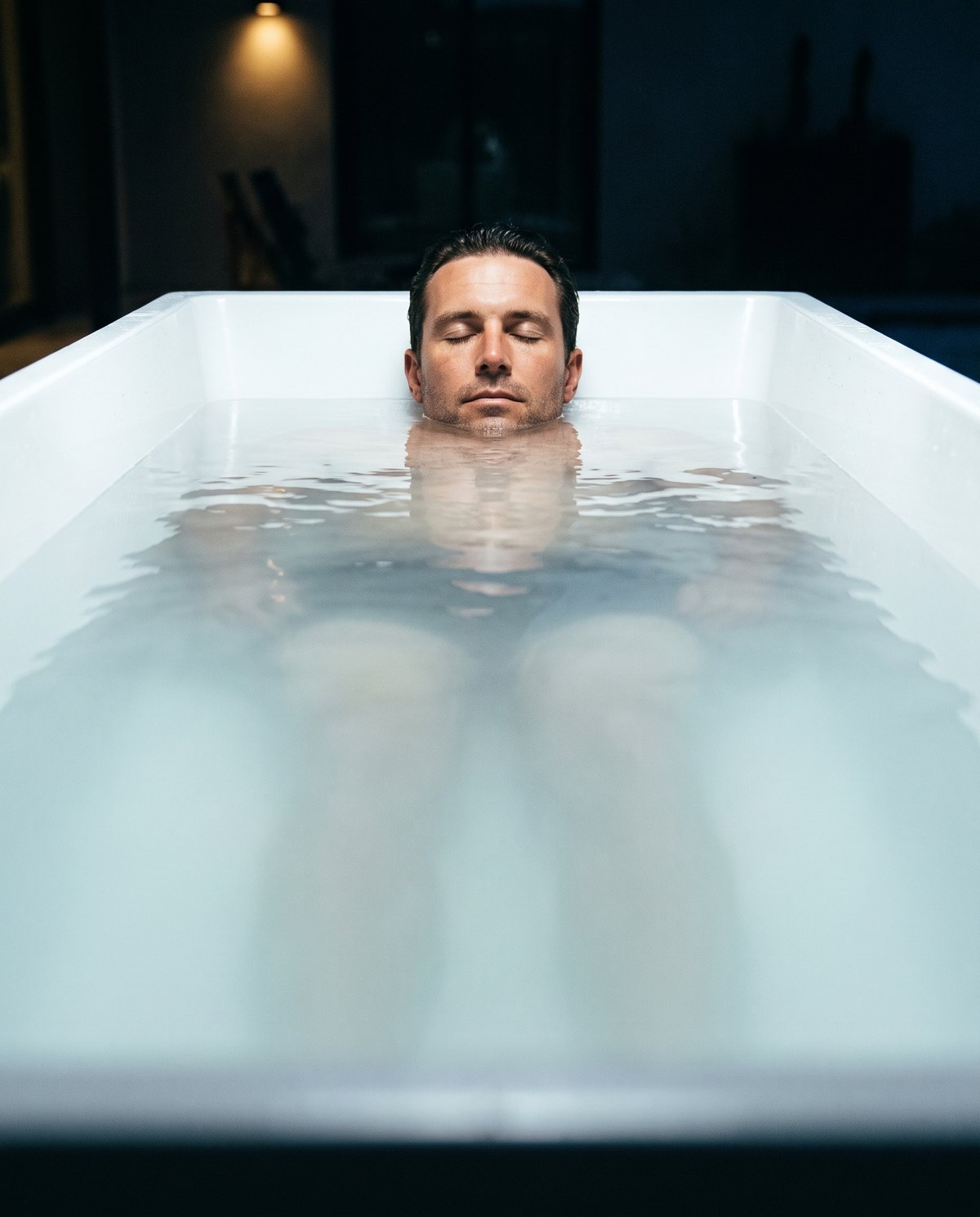 Man submerged to the chin in still cold plunge water